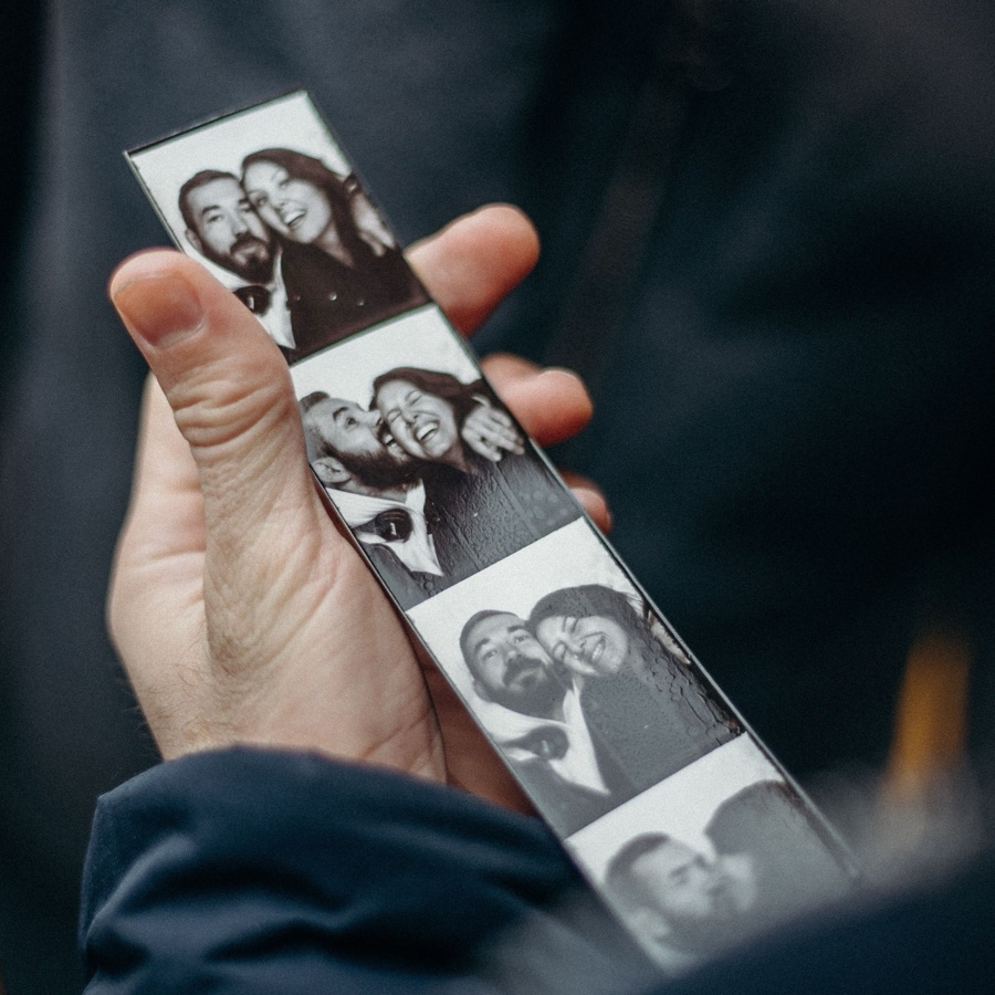 A hand holding a black-and-white photo strip.